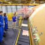 Artemis II NASA astronauts Reid Wiseman and Christina Koch of NASA, and CSA (Canadian Space Agency) astronaut Jeremy Hansen view the core stage for the SLS (Space Launch System) rocket at the agency’s Michoud Assembly Facility in New Orleans on Nov. 16.