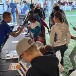 Matt Baeslack passes out kits for visitors to make a handheld solar eclipse.
