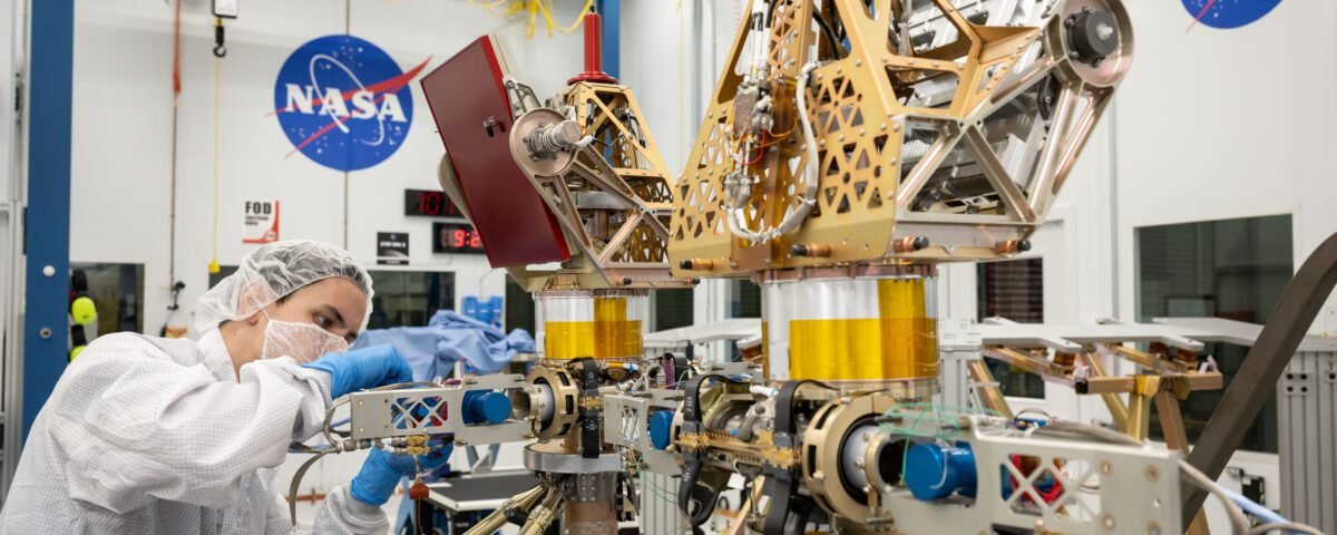 Engineers in white suits assemble and test NASA's first robotic Moon rover in a clean room at NASA's Johnson Space Center in Houston.